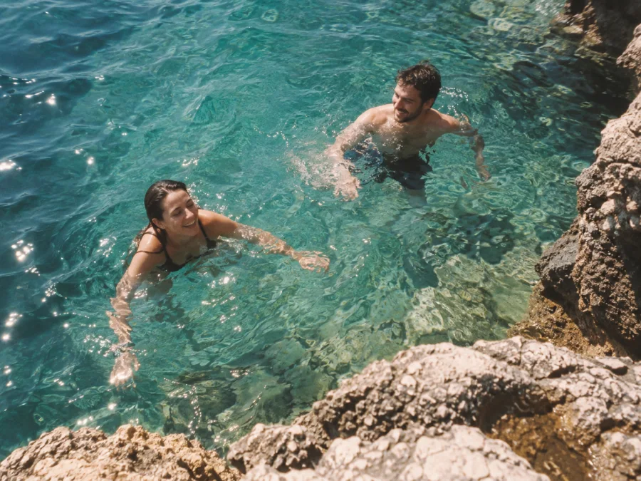 Two friends swim in turquoise water.